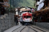 An Inca Rail DMU runs through the street at Aguas Calientes
